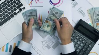 Para sayma iş adamı. Muhasebeci işyeri dizüstü, grafikler, hesap makinesi ile. Üstten Görünüm.