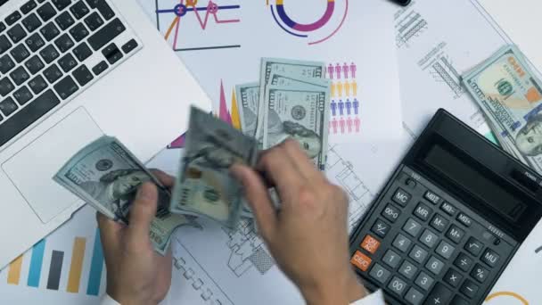 Zakenman tellen van geld. Accountant werkplek met laptop, grafieken, rekenmachine. Bovenaanzicht. — Stockvideo