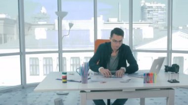 Erkek Emlak worling Emlak planları ile ofiste.