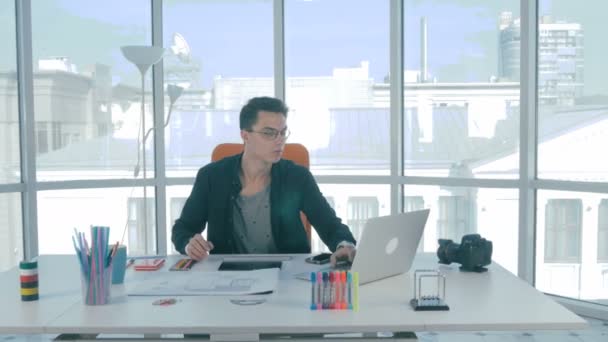 Giovane designer sul suo posto di lavoro sviluppando un'applicazione di telefonia mobile immobiliare . — Video Stock