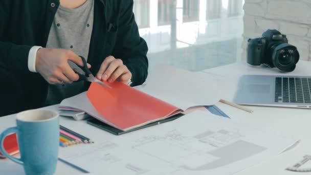 Onherkenbaar creatieve ontwerper werken in moderne kantoor. Snijden bladen, het kiezen van kleuren. Close-up. — Stockvideo