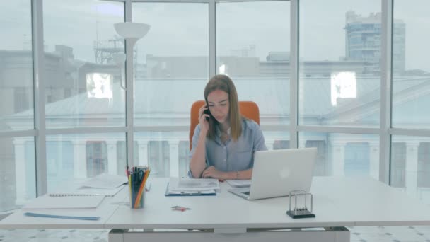 コンピューターで作業して、コール センターで電話で話している女性の受付. — ストック動画