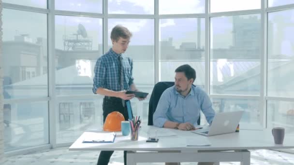 Jefe discutir proyecto con el empleado, da consejos, el uso de la tableta digital en la nueva oficina moderna . — Vídeos de Stock