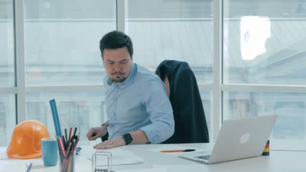 Un joven empresario está trabajando en una oficina moderna y luminosa . — Vídeo de stock