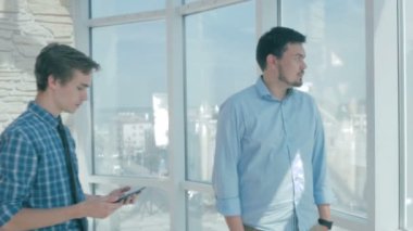 Patron ile yeni modern ofisinde dijital tablet kullanarak çalışan, tavsiye verir, proje tartışmak.