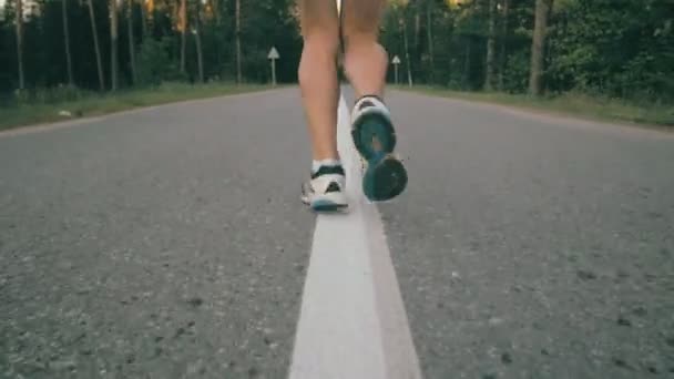 Žena běží na asfaltovou silnici, pomalý pohyb.