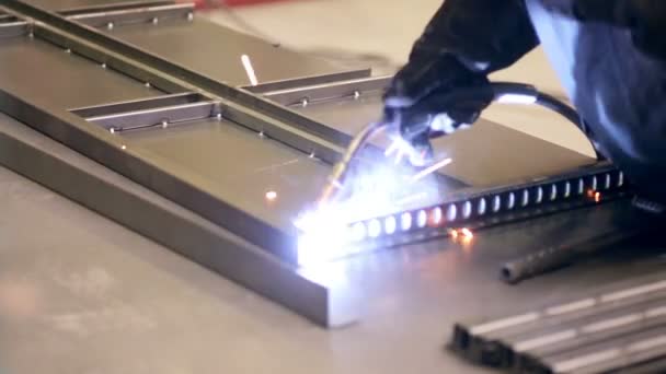 Svářeč v práci v továrně na metall. Svářečky, svařování kovových dílů. — Stock video