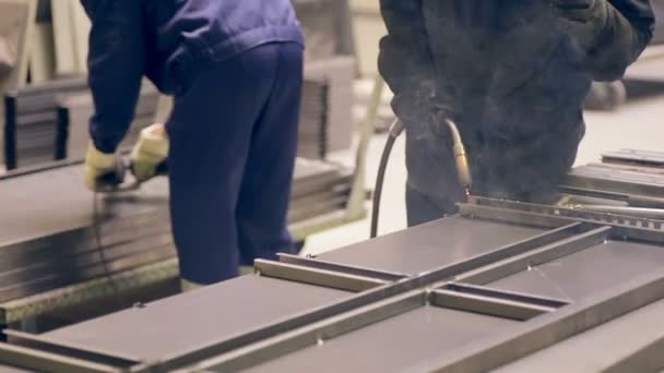 Två svetsare arbetar, svetsning metall bitar tillsammans på en fabrik. — Stockvideo