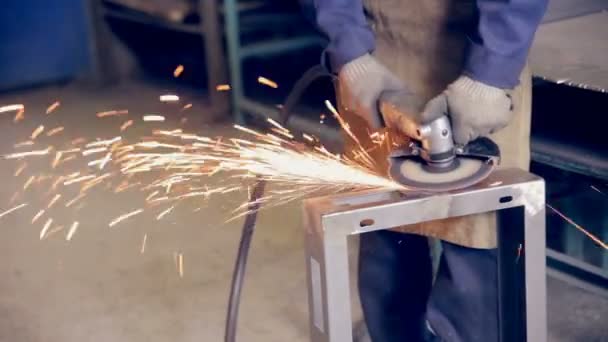 Trabajador que utiliza amoladora industrial que opera con metal en una planta de procesamiento de metales . — Vídeos de Stock