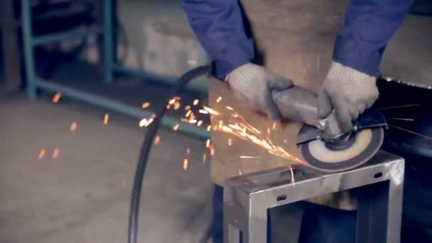 Trabajador que utiliza amoladora industrial que opera con metal en una planta de procesamiento de metales . — Vídeos de Stock