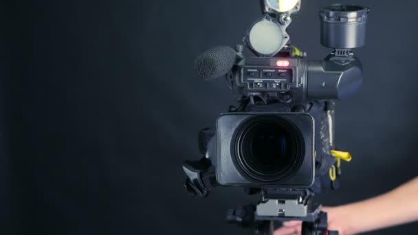 Camera operator working with a cinema broadcast camera at the unrecognizable tv news studio. — Stock Video