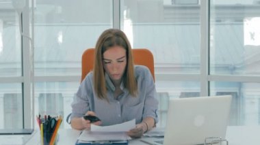 Genç iş kadını ile telefon ve bilgisayar modern ofis masasında.