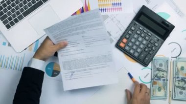 İşadamı işareti belge ve para nakit bize dolar faturaları ödeme anoyher adama verin. Üstten Görünüm.