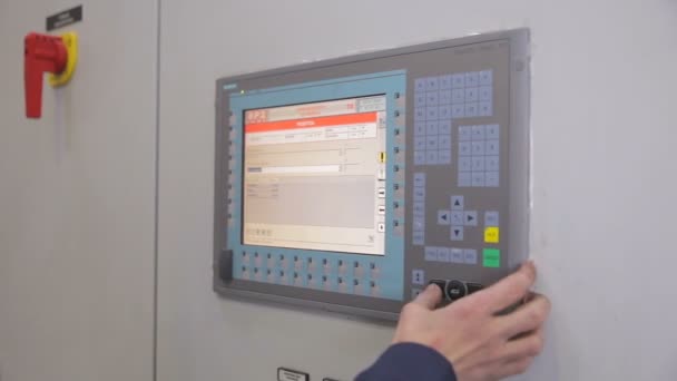 Невідомий працівник регулює роботу промислової машини на сенсорному екрані на промисловому заводі . — стокове відео