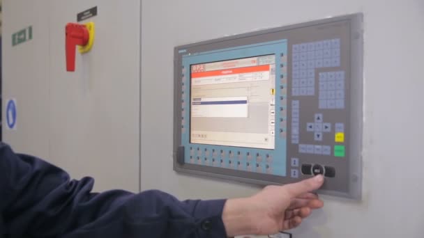 Невідомий працівник регулює роботу промислової машини на сенсорному екрані на промисловому заводі . — стокове відео