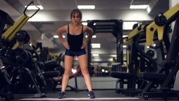 Chica joven haciendo ejercicios deportivos en el gimnasio. Fitness, deporte, estilo de vida saludable, concepto de levantamiento de pesas . — Vídeos de Stock