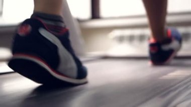 Yürüyüş ve spor salonunda koşu bandı üzerinde çalışan kadın bacaklar. Sağlıklı yaşam konsepti. Ağır çekim.