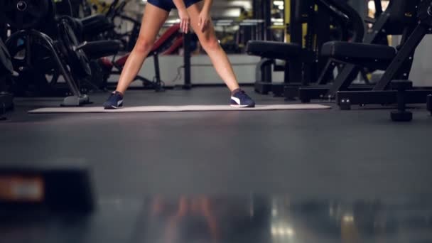 Chica joven haciendo ejercicios deportivos en el gimnasio. Fitness, deporte, estilo de vida saludable, concepto de levantamiento de pesas . — Vídeos de Stock