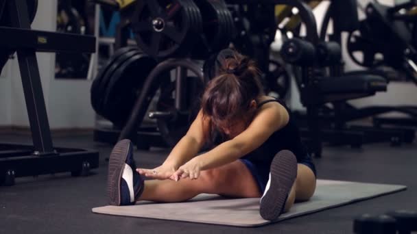 Ung flicka gör sport övningar i gymmet. Fitness, sport, hälsosam livsstil, tyngdlyftning koncept. — Stockvideo