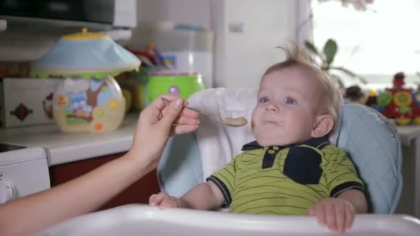 Madre alimentando al bebé, el niño llorando y negándose a comer. Concepto de niños y nutrición . — Vídeo de stock