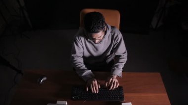 Erkek Arapça hacker bilgisayar karanlıkta kesmek. Yüzünde yansıtan bilgisayar kodu.