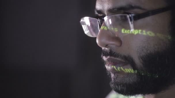 Datencode Reflexion auf Programmierern Gesicht. Hacker in Brille hacken nachts Programmcode. — Stockvideo