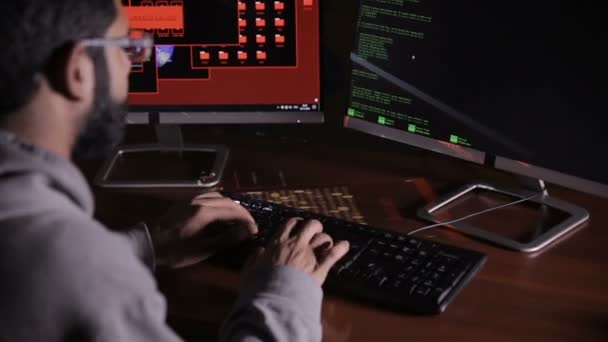 O hacker árabe macho invade o computador no escuro. Código de computador refletindo em seu rosto . — Vídeo de Stock