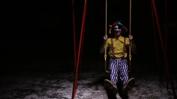 Griezelige clown in de straat, swingen. Afbeelding van de nachtmerrie. — Stockvideo