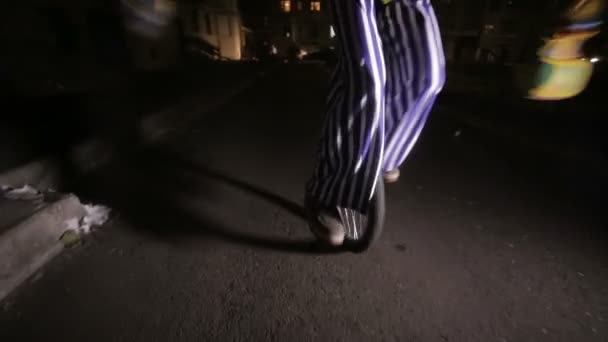 Sorgliga scary clown ridning på enhjulingar i en mörk gata. — Stockvideo