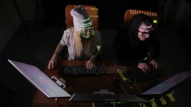 Genç erkek ve kadın hacker bilgisayar sistemine erişim kazanmaya çalışıyor.