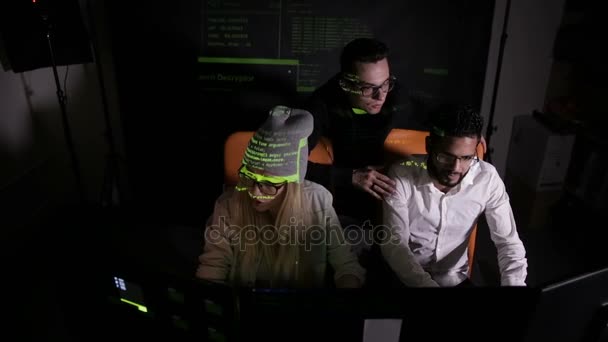 Equipo de profesionales multiétnicos de TI que trabajan con computadoras en sistemas informáticos oscuros y piratas informáticos . — Vídeo de stock