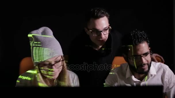 Команда мультиэтнических ИТ-специалистов, работающих с компьютерами в темноте, хакерская компьютерная система . — стоковое видео