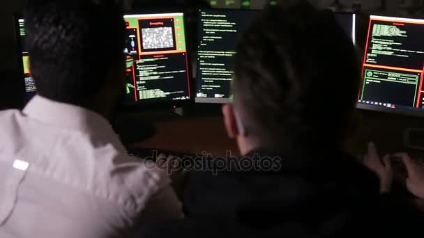 Equipo de profesionales multiétnicos de TI que trabajan con computadoras en sistemas informáticos oscuros y piratas informáticos . — Vídeos de Stock