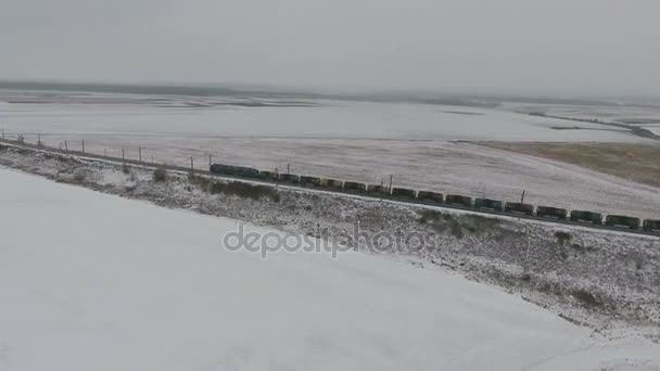 Tren de mercancías en el ferrocarril en invierno. Gasolina, tanques de combustible. Disparo aéreo . — Vídeos de Stock