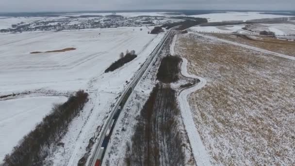 Aerial view of cargo train delivering goods, fuel, petrolium in winter. — Stock Video