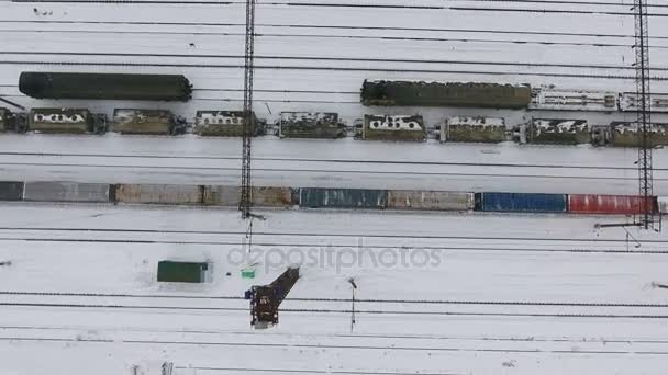 Long freight train coming on the railroad station in winter. Aerial shoot. — Stock Video