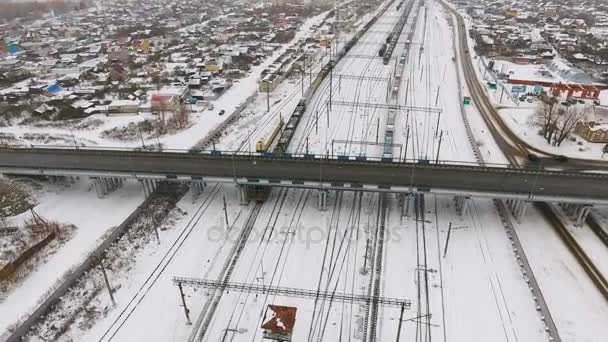 Frete, comboio de carga passando estação ferroviária no inverno. Disparo aéreo . — Vídeo de Stock