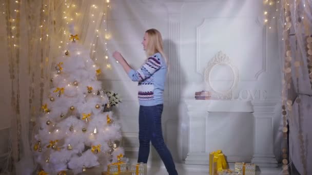 Linda joven hembra decorando el árbol de Navidad. Año nuevo próximo concepto . — Vídeo de stock
