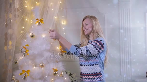 Красивая девушка украшает новогоднюю елку . — стоковое видео