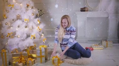 Noel hediyesi. Noel ağacı gösterir mevcut, yakın duygusal güzel kız heyecanlı geliyor yeni yıl tatilleri hakkında.