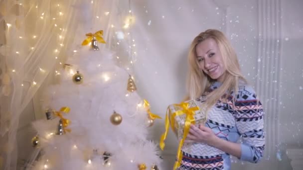 Christmas presents. Emotional pretty girl near christmas shows present, excited about new year holidays coming. — Stock Video