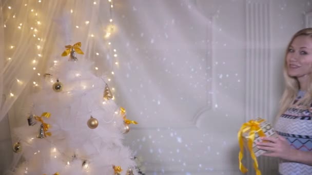 Kerstcadeaus. Emotionele mooi meisje in de omgeving van Kerstmis toont aanwezig, enthousiast over nieuwe jaar vakantie komen. — Stockvideo