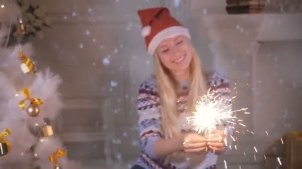 Щаслива усміхнена жінка з новорічними блискавками сміється і позує біля ялинки . — стокове відео