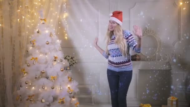 Schöne Mädchen lächelt in die Kamera und tanzt in der Nähe des Weihnachtsbaums. Silvester, Silvester, Weihnachten. — Stockvideo