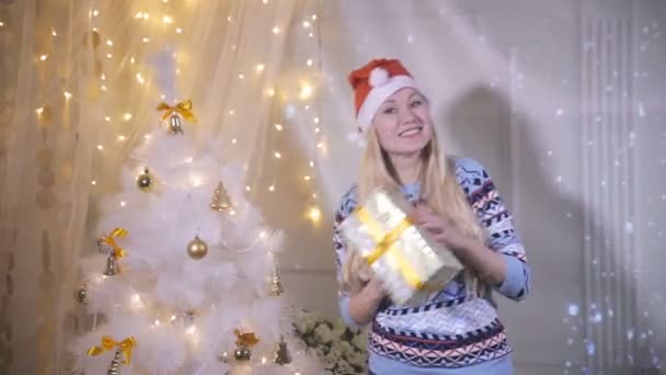 Feliz joven sonriente bailando cerca del Árbol de Navidad con regalo, regalos. Año Nuevo, Nochebuena, concepto de Navidad . — Vídeos de Stock