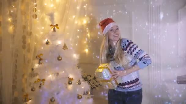 Glücklich lächelnde junge Frau tanzt neben Weihnachtsbaum mit Geschenk, Geschenken. Silvester, Silvester, Weihnachten. — Stockvideo