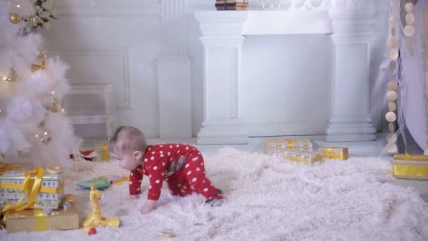 ベーグルを食べるクリスマス ツリーの近く 1 年間の赤ちゃん. — ストック動画