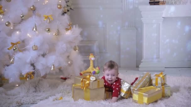 Baby spielt in der Nähe des Weihnachtsbaums. während der Neujahrsfeier. — Stockvideo