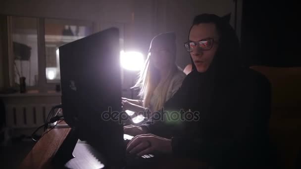 Jovem homem e mulher hackers tentando obter acesso a um sistema de computador . — Vídeo de Stock