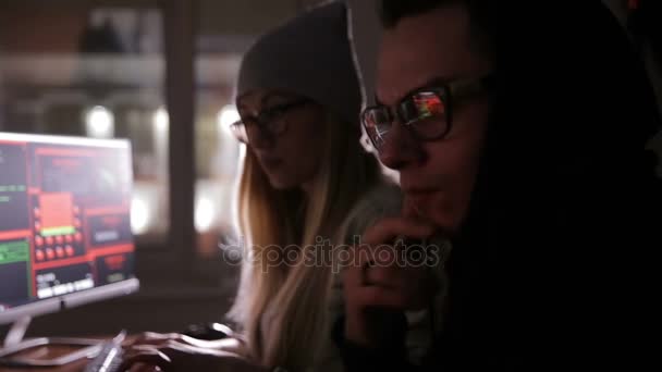 Jovem homem e mulher hackers tentando obter acesso a um sistema de computador . — Vídeo de Stock